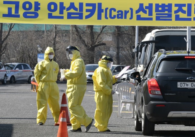Medical members guide a driver with suspected symptoms of the COVID-19 coronavirus, at a "drive-through" virus test facility in Goyang, north of Seoul, on February 29, 2020.Photo by Jung Yeon-je / AFP- Copyright ID4D, https://ideas4development.org/en/south-korea-effective-model-face-covid-19/
