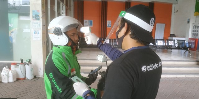 Driver GOJEK tampak antre cek kesehatan dan disinfeksi kendaraan di Posko Aman J3K di Kantor GOJEK Malang. (Foto: M Azmy/Tugumalang.id)