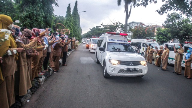 Sejumlah tenaga medis Dinas Kesehatan Kabupaten Bogor memberikan penghormatan terakhir kepada jenazah Kepala Puskesmas Banjarsari Dokter Usman, yang meninggal akibat COVID-19 di Jalan Raya Tegar Beriman, Kabupaten Bogor, Jawa Barat, Senin (26/10). Foto: Yulius Satria Wijaya/ANTARA FOTO