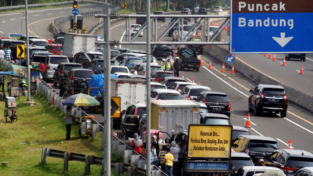 Sejumlah wisatawan keluar dari kendaraanya menunggu kemacetan reda akibat buka tutup jalan Puncak, Gadog, Kabupaten Bogor, Jawa Barat, Rabu (28/10). Foto: Yulius Satria Wijaya/ANTARA FOTO