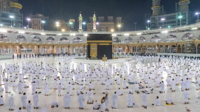 Jemaaah melaksanakan salat Shubuh berjamaah dengan menerapkan social distancing saat melaksanakan umrah di Masjidil Haram, Makkah, Arab Saudi. Foto:  Kantor Pers Saudi/via REUTERS