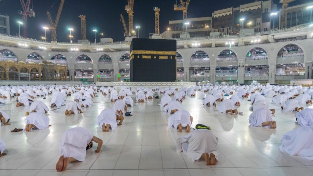 Jemaaah melaksanakan salat Shubuh berjamaah dengan menerapkan social distancing saat melaksanakan umrah di Masjidil Haram, Makkah, Arab Saudi. Foto: Kantor Pers Saudi/via REUTERS