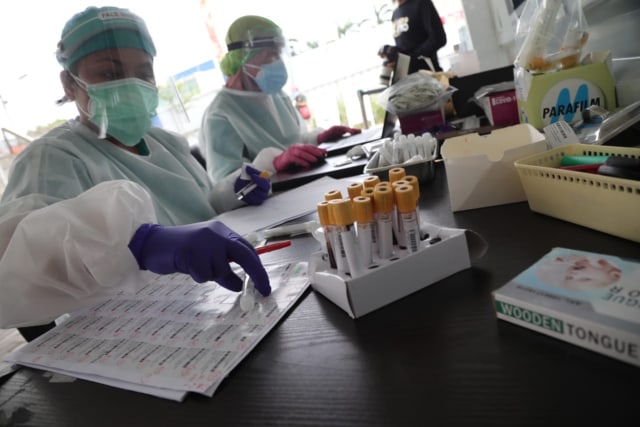 Petugas mengecek sampel di GSI Lab. Foto: Aditia Noviansyah/kumparan