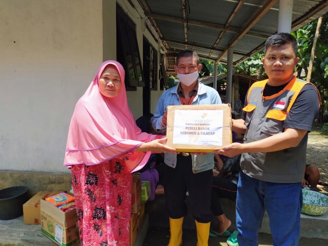 Mokhamad Miftahuddin, Staff Penyaluran Yatim Mandiri Purwokerto menyerahkan bantuan kemanusian untuk korban banjir di Kebumen.