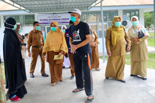 Salah seorang warga (tengah) pulang dari rumah sakit setelah sembuh dari corona. Foto: Suparta/acehkini 