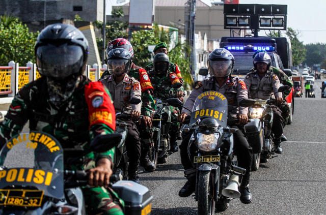 Petugas gabungan Babinsa TNI dan Bhabinkamtibmas Polri melakukan patroli untuk mensosialisasikan protokol kesehatan COVID-19 di Lhokseumawe. Foto: Rahmad/ANTARA FOTO