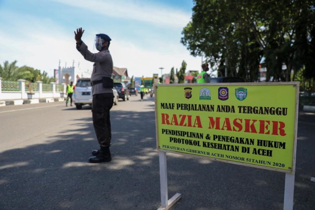 Petugas gabungan menggelar razia masker di jalan depan Masjid Raya Baiturrahman untuk mencegah penularan COVID-19 di Aceh, Senin (28/9). Foto: Suparta/acehkini