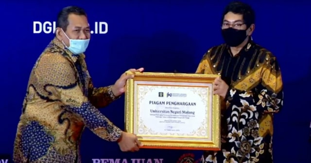 Dirjen DJKI Kemkumham, Freddy Haris, menyerahkan penghargaan IIPA Awards 2020 kepada Kepala Pusat HIKA LP2M UM, M Alfian Mizar, di Jakarta, pada Kamis malam (5/11/2020). Foto: dok 