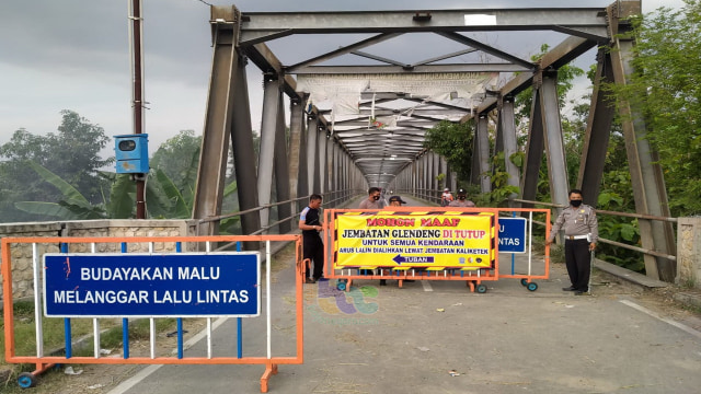 Petugas gabungan dari Sat Lantas Polres Bojonegoro dan Dinas Perhubungan Kabupaten Bojonegoro, saat lakukan penjagaan di Jembatan Glendeng, setelah dibuka untuk kendaraan roda 2 dan pejalan kaki. Senin (09/11/2020)