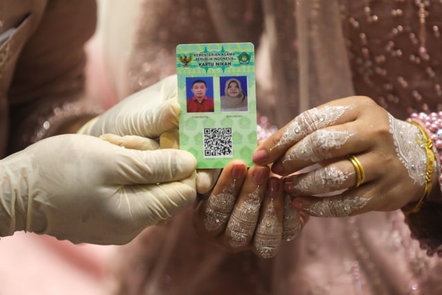 Pasangan pengantin di Aceh memperlihatkan kartu nikah. Meski pandemi COVID-19, Kemenag Aceh mencatat 3.840 peristiwa nikah sepanjang Oktober 2020. Foto: Suparta/acehkni