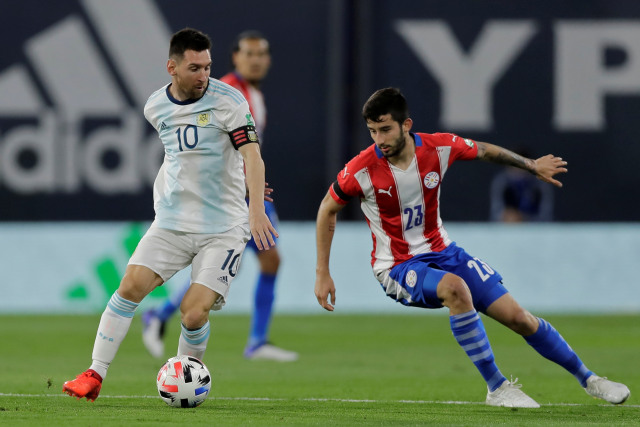 Pemain timnas Argetina Lionel Messi berebut bola dengan pemain timnas Paraguay Mathias Villasanti pada pertandingan kualifikasi Piala Dunia FIFA 2022 di Stadion La Bombonera di Buenos Aires, Argentina. Foto: Ignacio RONCORONI / Pool / AFP