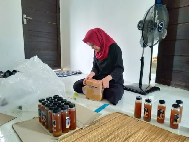 Salah seorang karyawan Zulkifli mengemas wedang jahe dalam kardus. Foto: Dok. Hi!Pontianak