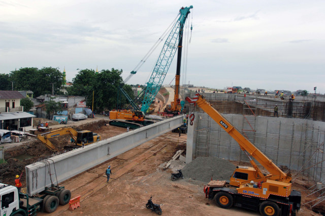 Pekerja dengan menggunakan alat berat menyelesaikan proyek pembangunan ruas jalan Tol Kunciran-Cengkareng di Cipondoh, Tangerang, Banten. Foto: Muhammad Iqbal/Antara Foto