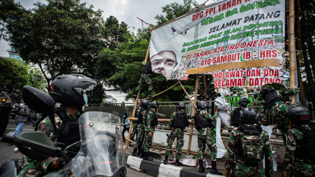 Prajurit TNI menertibkan spanduk tidak berizin saat patroli keamanan di Petamburan, Jakarta, Jumat (20/11). Foto: Aprillio Akbar/ANTARA FOTO