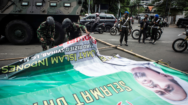 Prajurit TNI menertibkan spanduk tidak berizin saat patroli keamanan di Jalan Budi Kemuliaan, Gambir, Jakarta, Jumat (20/11).  Foto: Aprillio Akbar/ANTARA FOTO