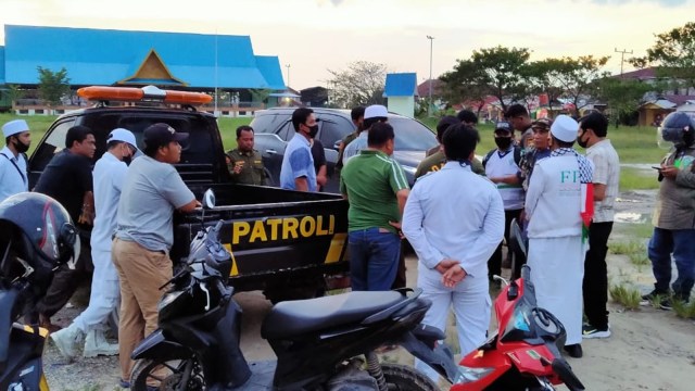 ANGGOTA Linmas dan Satpol PP bersitegang dengan FPI Bengkalis saat penurunan dua baliho bergambar Rizieq Shihab yang terpasang di Kecamatan Bathin Solapan, Bengkalis, Riau.   