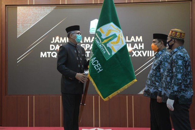 Penyerahan pataka Pemerintah Aceh sebagai tanda penglepasan kafilah Aceh yang mengikuti MTQ Nasional XXVIII Tahun 2020 ke Padang, Senin (9/11) malam. Foto: Dok. Humas Setda Aceh