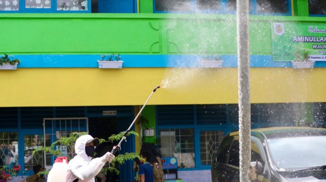 Petugas melakukan penyemprotan disinfektan di SD Negeri 37 Kota Banda Aceh, Kamis (19/11). Foto: Suparta/acehkini