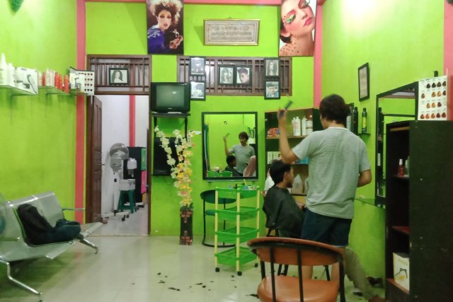Pekerja salon di Aceh Barat saat memangkas rambut seorang pelanggan. Foto: Siti Aisyah/acehkini