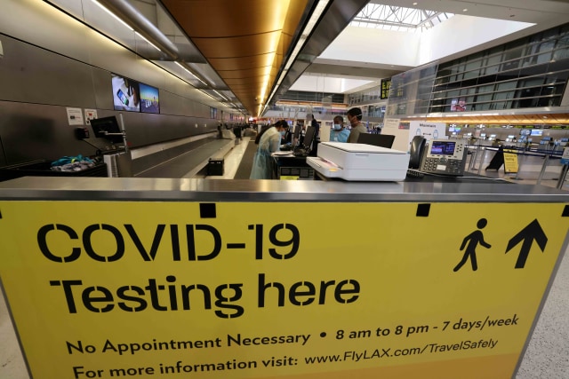 Papan informasi di terminal internasional Tom Bradley di bandara LAX, di Los Angeles, California, Amerika Serikat. Foto: Lucy Nicholson/Reuters