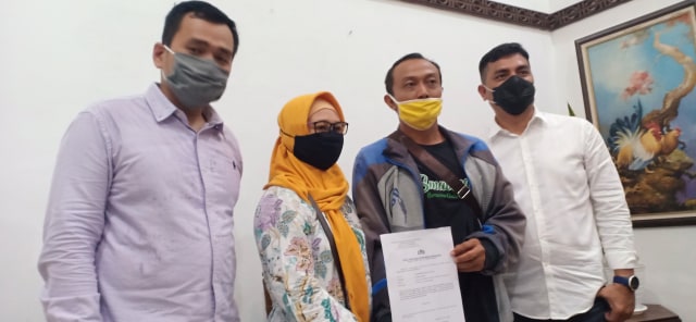 Korban dan kuasa hukum ketika menunjukkan laporan kepolisian atas raibnya uang rekening di Maybank