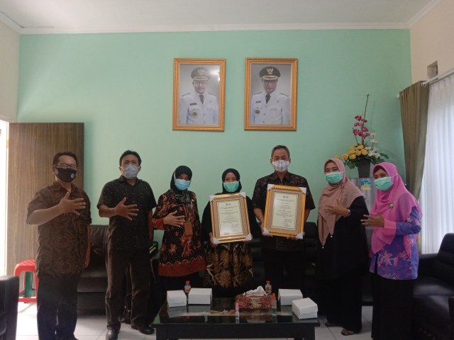 Dinas Kesehatan saat menyerahkan piagam kepada Kelurahan Tunjungsekar secara simbolis. Kepala Bidang Kesehatan Masyarakat (Kesmas) Dinkes Kota Malang, Latifah Hanun (tiga dari kiri). Yeni Purwati (empat dari kiri), dan Subhan Effendy, ST, M. AP (lima dari kiri). Foto: Feni.