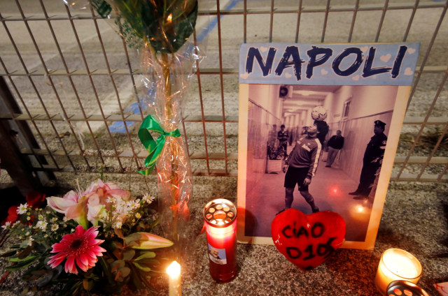 Bunga, lilin, dan foto Diego Maradona diletakkan di luar Stadion San Paolo di Napoli, Italia, Rabu (25/11). Foto: REUTERS/Yara Nardi