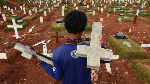 Pekerja mengangkut nisan untuk warga yang meninggal akibat virus corona di TPU Pondok Ranggon, Jakarta, Kamis (26/11). Foto:  Indrianto Eko Suwarso /ANTARA FOTO