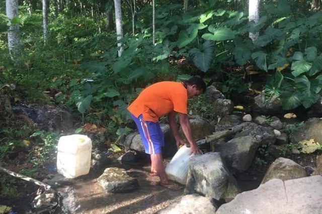 Flori, Warga Kampung Gumbang sedang mengambil air kali yang jaraknya 1 Km dari Kampung Gumbang, Desa Riung.