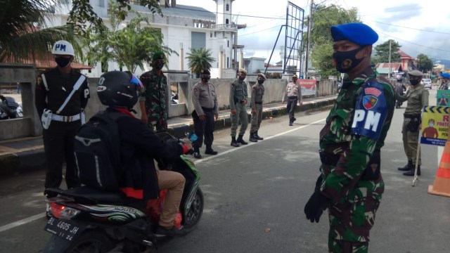 Petugas gabungan saat menggelar razia protokol protokol kesehatan di jalan depan Masjid Jami' Lueng Bata, Banda Aceh. Foto: Habil Razali/acehkini