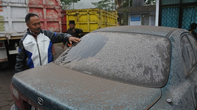 Warga menunjukkan abu vulkanik Gunung Semeru di kaca mobil saat mengungsi di Kecamatan Pronojiwo, Lumajang, Jawa Timur, Selasa (1/12). Foto: Seno/ANTARA FOTO