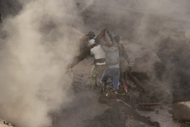 Proses evakuasi sejumlah alat berat dan dump truck pertambangan pasir yang tertimbun material endapan lahar Gunung Semeru, pada Rabu (2/12/2020). Foto: Ben