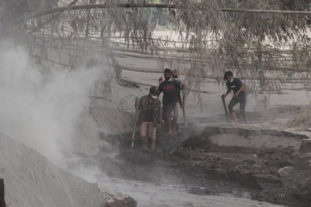 Proses evakuasi sejumlah alat berat dan dump truck pertambangan pasir tertimbun material endapan lahar Gunung Semeru, pada Rabu (2/12/2020). Foto: Ben