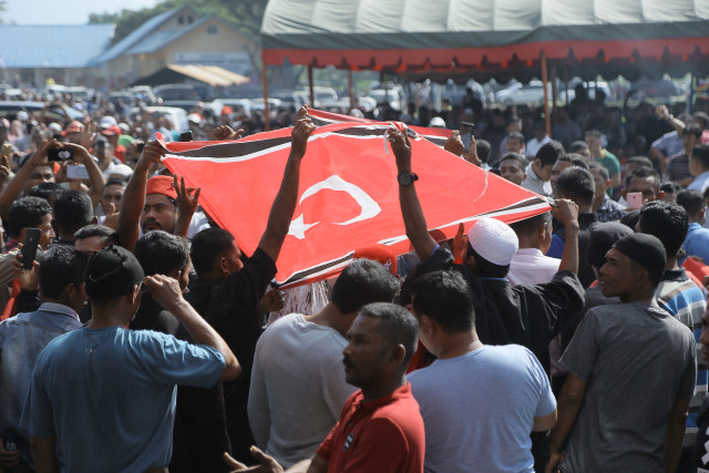 Eks kombatan GAM mengusung bendera bintang bulan pada silaturrahmi di Makam Hasan Tiro. Foto: Abdul Hadi/acehkini 