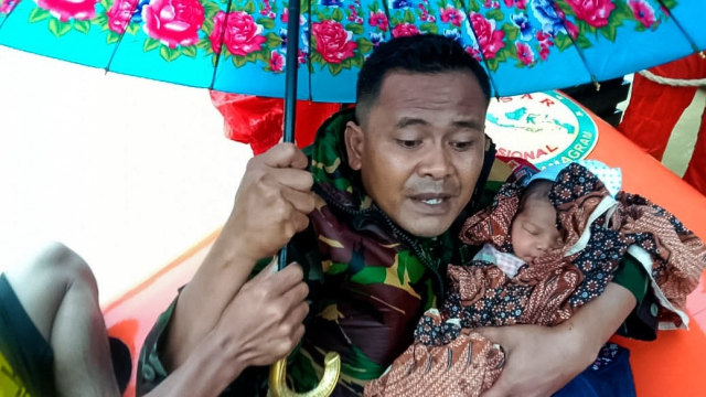 Anggota TNI mengevakuasi bayi yang terjebak banjir di Aceh Timur. Dok. Laung/TNI