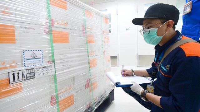 Petugas mengecek kontainer berisi vaksin COVID-19 Sinovac saat tiba di Bio Farma, Bandung, Jawa Barat. Foto: Muchlis Jr/Biro Pers Sekretariat Presiden