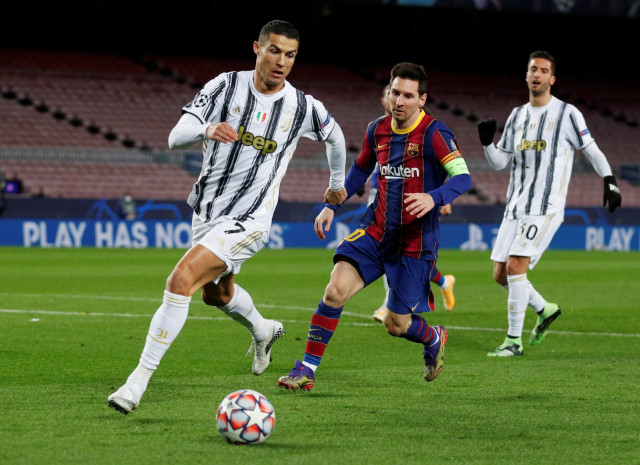 Pemain Juventus Cristiano Ronaldo menggiring bola melewati pemain FC Barcelona Lionel Messi pada pertandingan Liga Champions, di Stadion Camp Nou, Barcelona, Spanyol, (8/12). Foto: Albert Gea/REUTERS