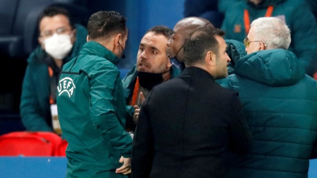 Sebastian Coltescu berbicara dengan asisten pelatih Istanbul Basaksehir Pierre Webo saat pertandingan dihentikan, di Parc des Princes, Paris, Prancis, (8/12). Foto: Charles Platiau/REUTERS