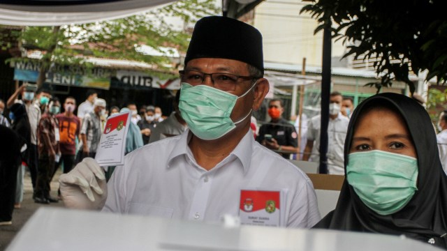 Calon Wali Kota Medan nomor urut 1 Akhyar Nasution (kiri) bersama istri Nurul Khairani (kanan) menggunakan hak pilihnya pada Pilkada Kota Medan di TPS 22 Kecamatan Medan Timur, Kota Medan, Sumatera Utara, Rabu (9/12).  Foto: Rony Muharrman/ANTARA FOTO