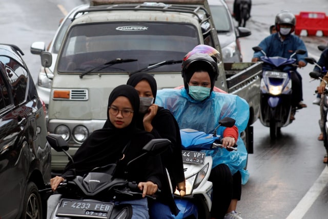 Warga mengendarai sepeda motor tanpa menggunakan helm dan masker di Puncak, Kabupaten Bogor, Jawa Barat. Foto: Yulius Satria Wijaya/ANTARA FOTO