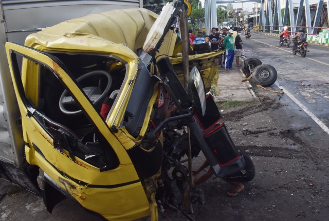 Warga melihat kondisi truk yang hancur akibat kecelakaan. Foto: ANTARA FOTO/Siswowidodo