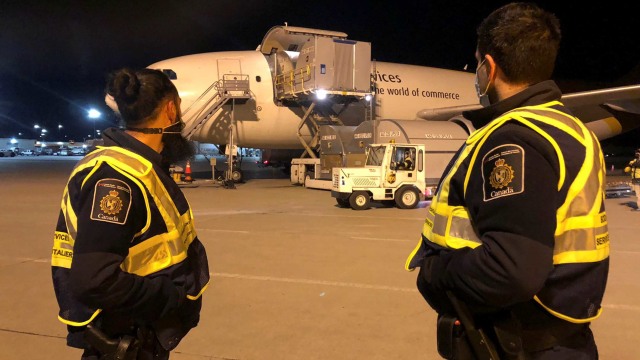 Petugas Badan Layanan Perbatasan Kanada (CBSA) mengawasi saat batch pertama vaksin Pfizer / BioNTEch COVID-19 tiba di Montreal, Kanada. Foto: CBSA/Handout via REUTERS