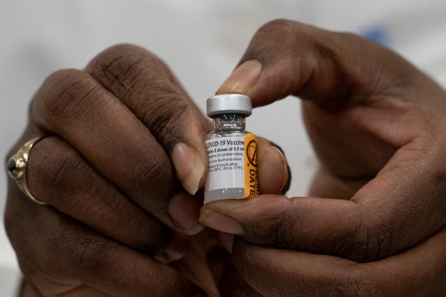 Seorang dokter menunjukkan vaksin corona di Long Island Jewish Medical Center di New Hyde Park, New York, AS, Senin (14/12).  Foto: Mark Lennihan/Pool/REUTERS