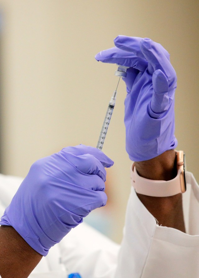 Ilustrasi seorang dokter bersiap untuk memberikan vaksin corona.  Foto: Mark Lennihan/Pool/REUTERS 