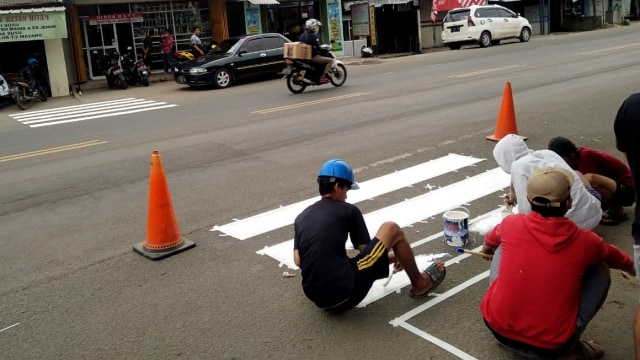 Para pemuda Kecamatan Cikande bergotong-royong melakukan pengecatan zebra cross secara swadaya sejak Minggu (13/12) sampai Senin (14/12). Foto: Dok. Istimewa
