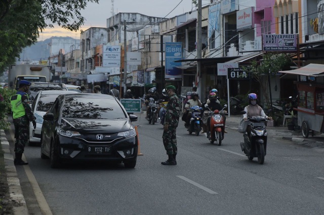 Aparat gabungan di Aceh saat menggelar razia protokol kesehatan COVID-19 di Jalan Teuku Umar, Kota Banda Aceh, Senin (14/12) sore. Foto: Abdul Hadi/acehkini