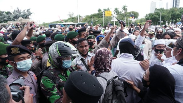 Massa dari berbagai ormas Islam dipaksa mundur oleh polisi, saat demo di kawasan Patung Kuda, Jakarta, Jumat (18/12). Foto:  Jamal Ramadhan/kumparan
