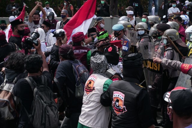 Petugas polisi memukul mundur massa aksi PA 212, di Jakarta, Jumat (18/12). Foto: Jamal Ramadhan/kumparan