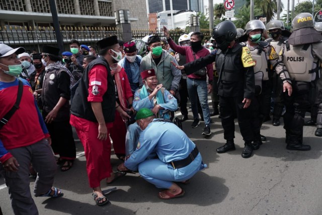 Petugas keamanan berjaga di persimpangan Patung Kuda dan Halte Bank Indonesia untuk menghalau massa. Foto: Jamal Ramadhan/kumparan