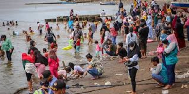 Foto masyarakat melanggar protokol kesehatan di sebuah pantai.